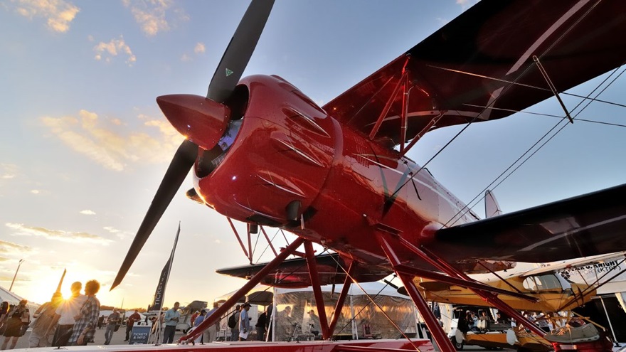 The sun sets behind a Waco biplane on amphibious floats during the 2017 AOPA Tampa Fly-In. Photo by Mike Collins.